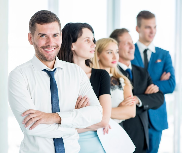 Free photo portrait of a happy manager with his employees standing in a row
