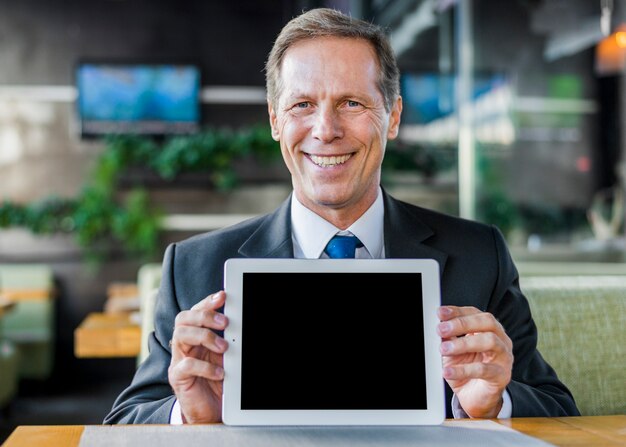 Portrait of a happy mature businessman showing digital tablet