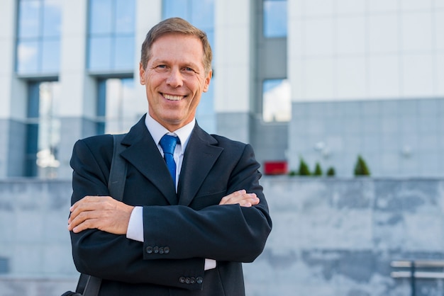 Portrait of a happy mature businessman with folded arms