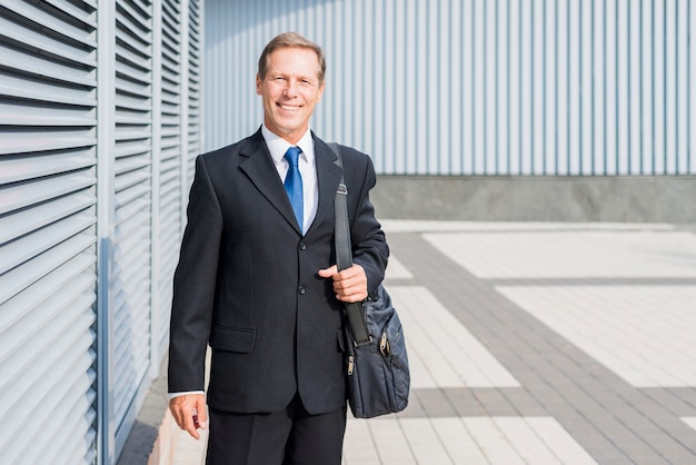 Portrait of a happy mature businessman with handbag