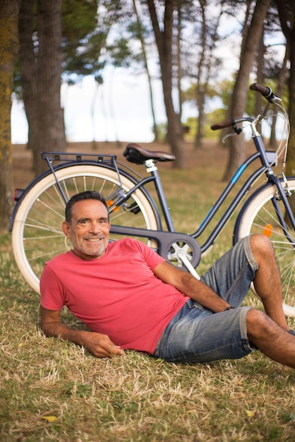 Ritratto di uomo maturo felice che riposa in bici