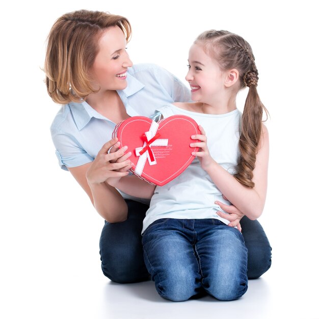 Portrait of happy mother and young daughter hold gift for birthday  - isolated