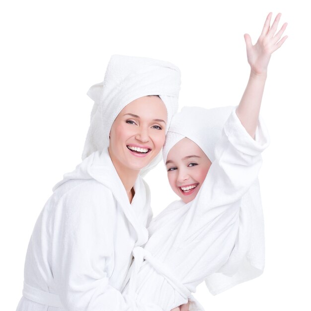 Портрет счастливой матери и молодой дочери в белом халате и изолированном полотенце. Концепция счастливых семейных людей.