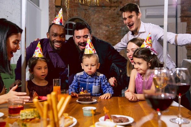 Ritratto di famiglia multietnica felice che celebra un compleanno a casa