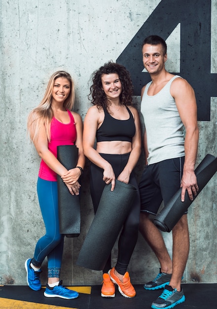 Free photo portrait of happy people with exercise mat