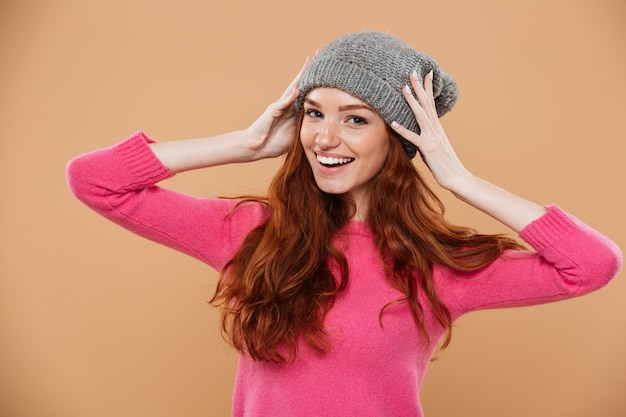 Portrait of a happy pretty redhead girl with winter hat