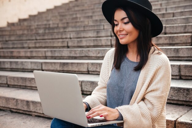 Portrait of a happy pretty woman using laptop computer