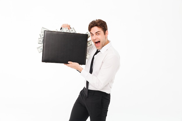 Portrait of a happy satisfied businessman showing briefcase