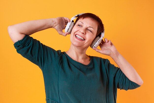 Portrait of happy senior woman listening to music