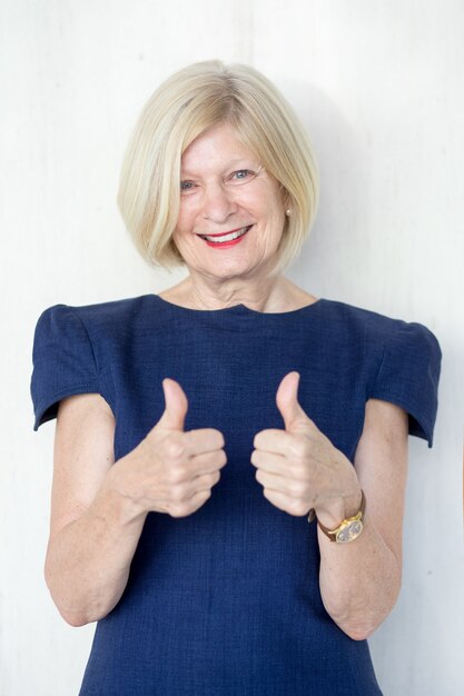 Free photo portrait of happy senior woman showing thumbs up