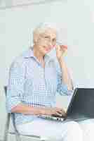 Free photo portrait of happy senior woman with laptop