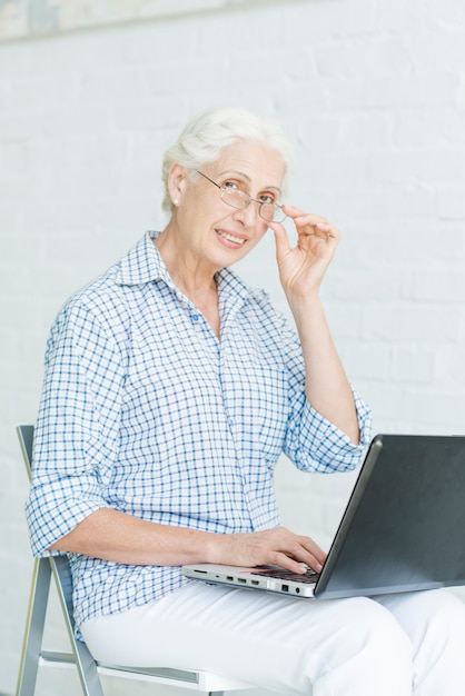 Portrait of happy senior woman with laptop