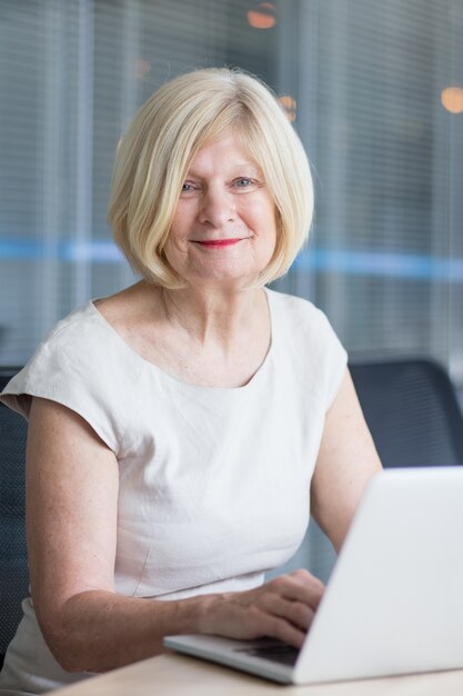 Portrait of happy senior woman working in office