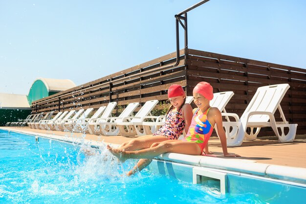 The portrait of happy smiling beautiful teen girls at the swimming pool.