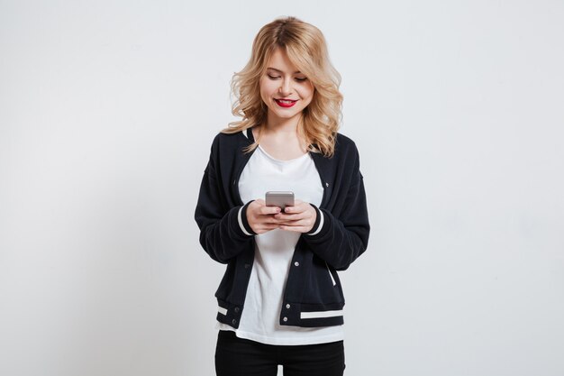 Portrait of a happy smiling casual woman holding mobile phone