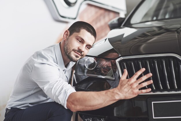 キャビンで新しい車を選ぶ幸せな笑顔の男の肖像画。