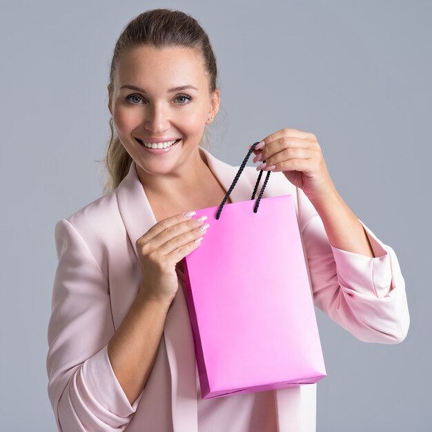 핑크 쇼핑 가방과 함께 행복 하 게 웃는 여자의 초상화.