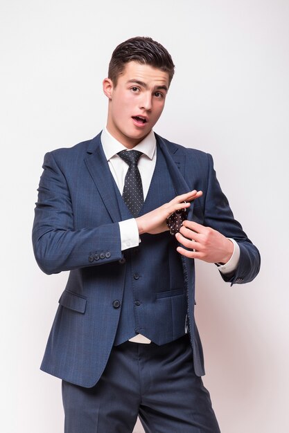 Portrait of happy smiling young businessman in blue suit isolated on white wall