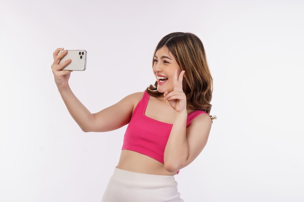 Portrait of happy smiling young woman selfie with smartphone isolated over white background