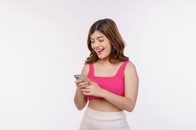 Портрет счастливой улыбающейся молодой женщины с помощью мобильного телефона на белом фоне
