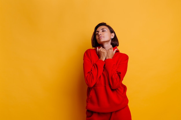 Portrait of happy tanned fit woman wearing trendy warm red fleece hoodie and pants