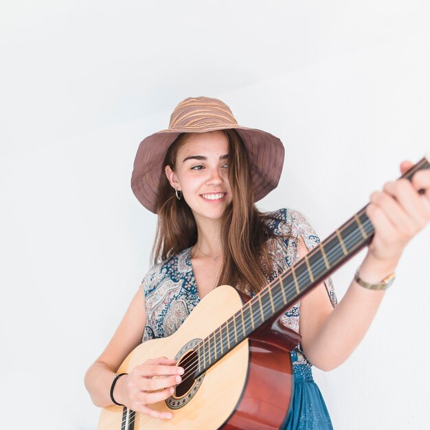 흰색 배경에 기타를 연주 행복한 십대 소녀의 초상