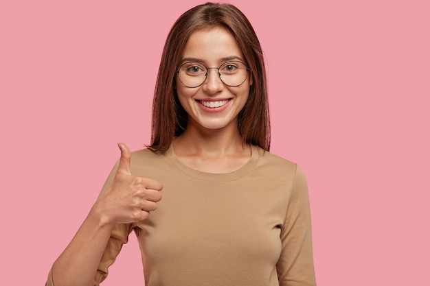 Портрет счастливого подростка с поднятым пальцем, в хорошем настроении, показывает свое согласие