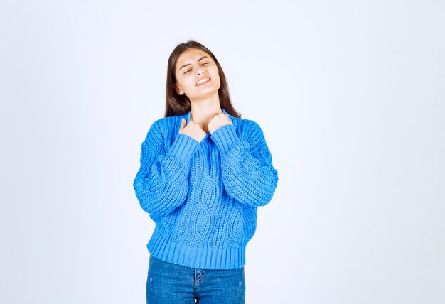 Portrait of happy woman in blue sweater feeling hot on white.