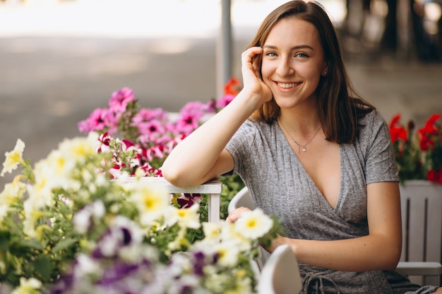 Ritratto di una donna felice in un caffè con i fiori