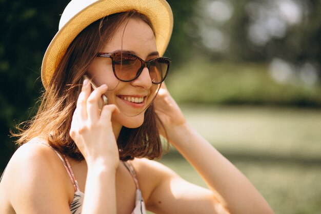 Portrait of a happy woman in hat talking on the phone