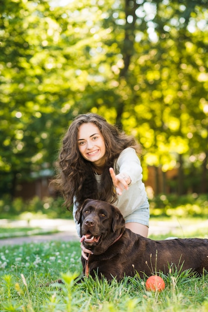 Portrait of a happy woman having fun with her dog in garden