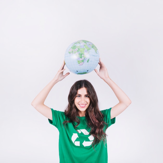 Free photo portrait of a happy woman holding globe over her head