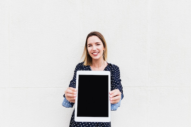 Портрет счастливой женщины, держащей большой цифровой планшет