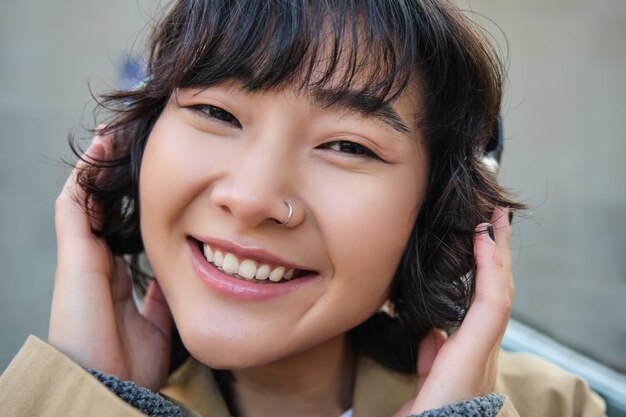 Portrait of happy woman korean girl in headphones listening music in headphones enjoying sound of ea