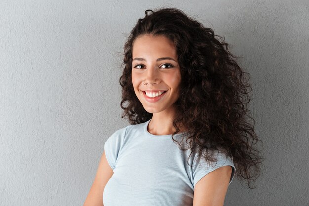 Portrait of happy woman posing isolated over grey