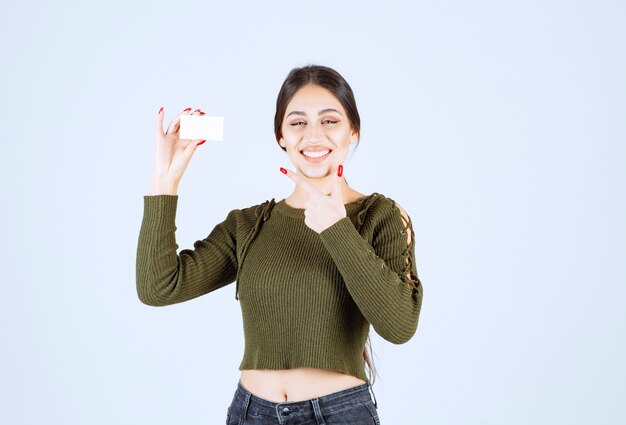 Portrait of happy woman showing blank business card.