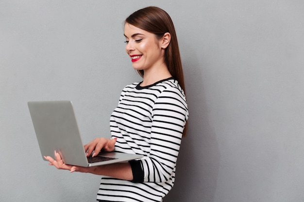 Free photo portrait of a happy woman using laptop computer