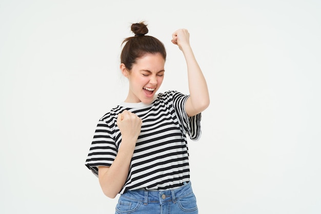 Foto gratuita ritratto di una donna felice che vince, che celebra la vittoria, che sostiene la squadra che trionfa, in piedi sopra il bianco.