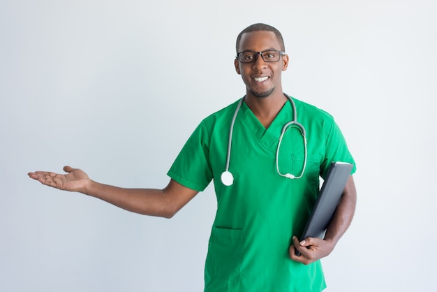 Portrait of happy young African American doctor showing palm.