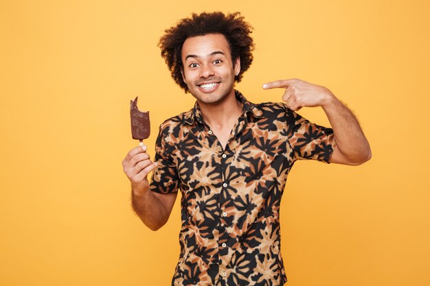 Portrait of a happy young african man eating ice cream