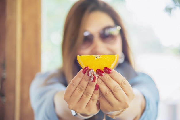 Free photo portrait happy young asian lady eating orange