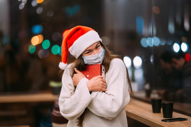 Portrait happy young beautiful woman hold gift box and smile in cafe