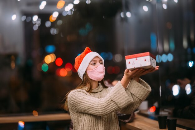 Portrait happy young beautiful woman hold gift box and smile in cafe