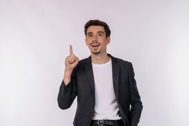 Portrait of happy young businessman having great idea over studio background