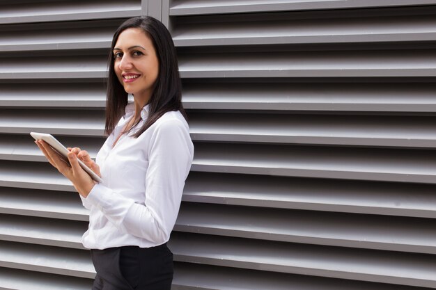 Portrait of happy young businesswoman using digital tablet