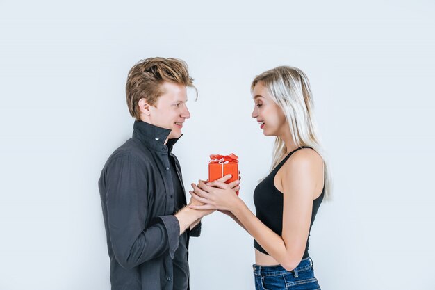 행복 한 젊은 커플의 초상화는 선물 상자와 함께 깜짝 사랑