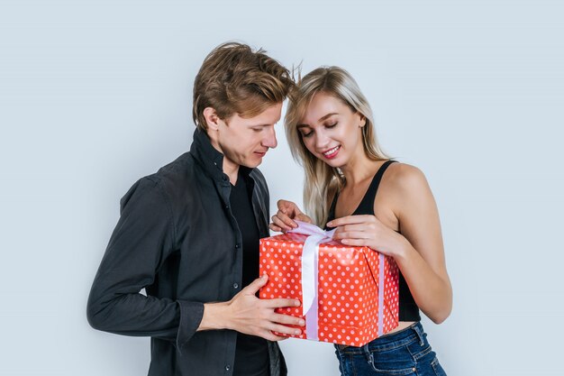 행복 한 젊은 커플의 초상화는 선물 상자와 함께 깜짝 사랑