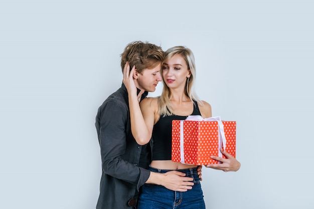 Портрет счастливой молодой пары любят вместе сюрприз с подарочной коробке