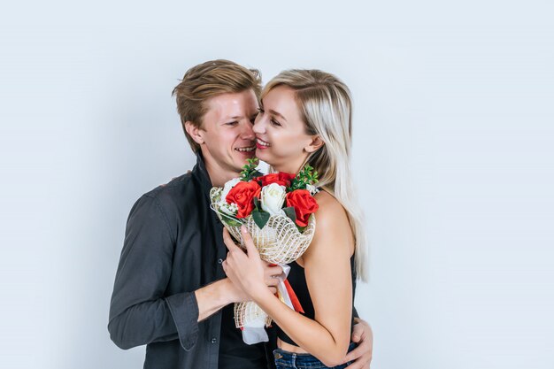 花と一緒に愛する幸せな若いカップルの肖像画