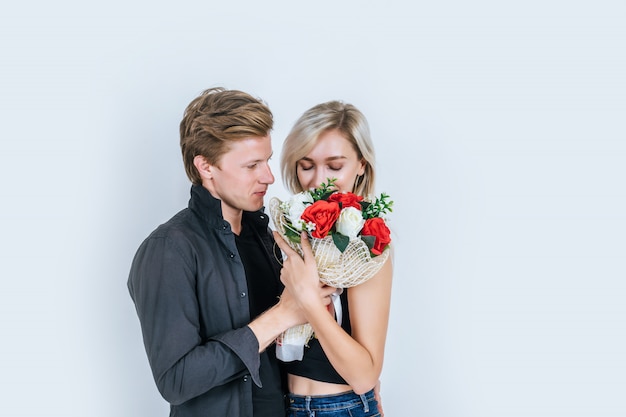 花と一緒に愛する幸せな若いカップルの肖像画